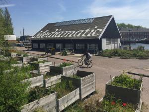 uma pessoa a andar de bicicleta em frente a um edifício em Houseboat Dokstroom em Amsterdã