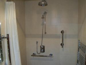 a bathroom with a shower with a shower curtain at cosy ground floor disabled friendly room in farm house in Bala