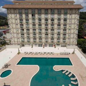 un hôtel avec une piscine en face d'un bâtiment dans l'établissement Flat 314 Granja Brasil Itaipava, à Itaipava