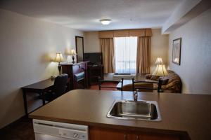 a hotel room with a kitchen and a living room at Peavine Inn & Suites in High Prairie
