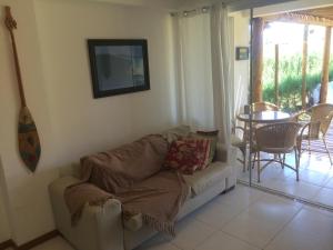 ein Wohnzimmer mit Sofa und Tisch in der Unterkunft Paraiso dos Corais in Guarajuba
