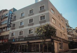 un edificio con un cartel en el costado en The Koos Hotel Dahu, en Taipéi