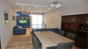 un soggiorno con tavolo e divano blu di Le Petit Monde - Eleganza e relax in centro a Abano Terme ad Abano Terme