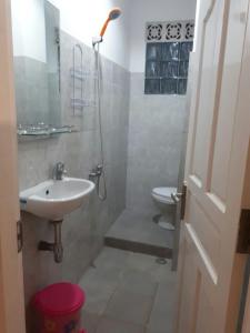 a bathroom with a sink and a toilet at Anggrek Mas Bed & Breakfast in Ubud