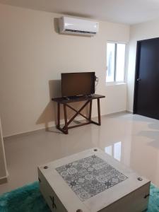 a room with a tv and a table with a box at Departamento zona dorada in Mazatlán