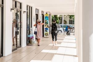 Ein Mann und eine Frau, die auf dem Bürgersteig spazieren in der Unterkunft Hotel Plaza Playa in Playa del Carmen