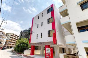 a white building with red accents on a street at Terrace Resort 8 in Ginowan