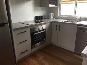 a kitchen with a stove and a sink at Glenaire apartments at Pontifex in Strahan