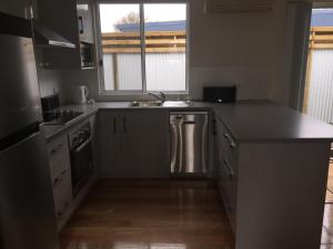 a kitchen with a sink and a counter top at Glenaire apartments at Pontifex in Strahan