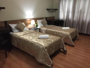 um quarto de hotel com duas camas e uma mesa em The Studio 87 Residences em Manila