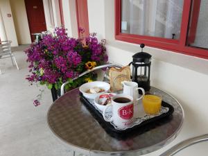 ein Tablett mit Tassen Kaffee auf einem Tisch mit Blumen in der Unterkunft BK's Rotorua Motor Lodge in Rotorua