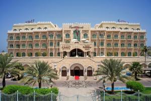 a large building with a large clock on the front of it at Grand Hyatt Muscat in Muscat