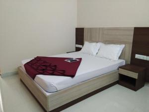 a bedroom with a bed with a red blanket on it at Grand Empark in Bangalore