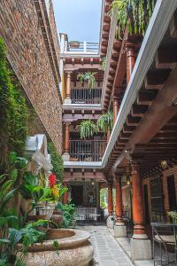 a building with a courtyard with plants and stairs at Casa Mia Hotel in Antigua Guatemala