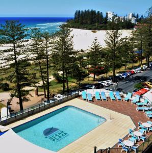 uma piscina com cadeiras e a praia em Ocean Plaza Resort em Gold Coast