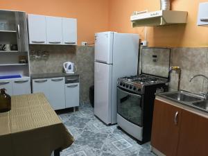 a kitchen with a stove and a refrigerator at Hostal Tricontinental in Valparaíso