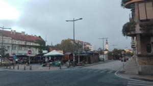 Une rue dans une ville avec un vendeur de rue au coin de la rue dans l'établissement Apartments Girasole, à Novi Sad