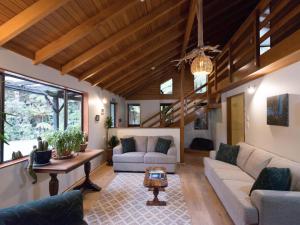 a living room with two couches and a table at Te Nikau Retreat in Punakaiki