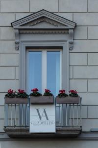a window on a building with red flowers on it at Villa Avellino Historic Residence in Pozzuoli