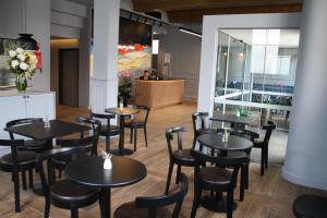 a restaurant with black tables and chairs and a counter at Mrs Banks Hotel in Sydney