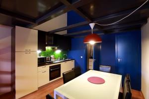 a kitchen with a white table and a blue wall at Alojamiento ciudad las artes in Valencia
