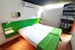 a bedroom with a green and white bed in it at Alojamiento ciudad las artes in Valencia