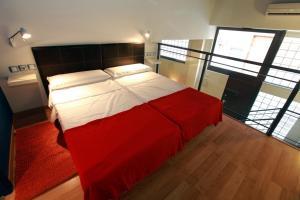 a bedroom with a large bed with red and white sheets at Alojamiento ciudad las artes in Valencia