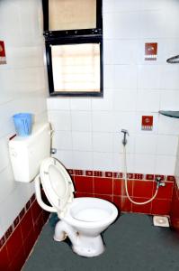 a bathroom with a white toilet and a window at Radhanand Holiday Home in Panhāla