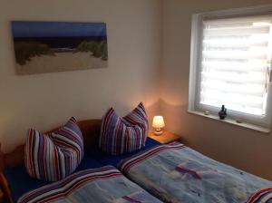 a bedroom with a bed with pillows and a window at Haus Irma in Zingst