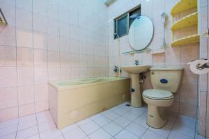 Un baño con bañera, inodoro y lavabo. en Happy Garden Homestay, en Taitung