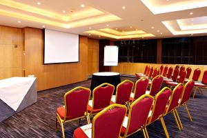 a conference room with red chairs and a podium at Courthouse Hotel London in London +77 photos