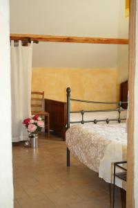 a bedroom with a bed and a vase of flowers at Gîte La Grange Du Haut in Saint-Antoine