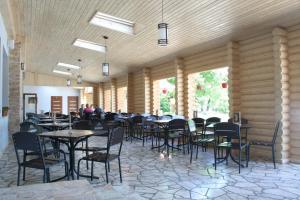 a restaurant with tables and chairs in a room at Hotel Helikon in Yanoshi