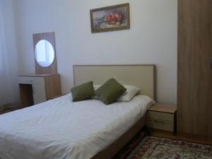 - une chambre avec un lit blanc et 2 oreillers verts dans l'établissement Apartment 115 Expo Boulevard, à Astana
