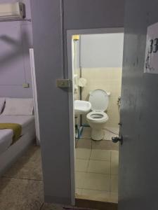 a bathroom with a toilet and a sink at Scandalic Bar and Guest house in Pattaya Central