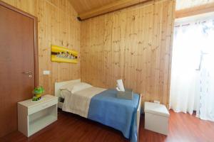 1 dormitorio con 1 cama y pared de madera en Acqua di Mare, en Locogrande