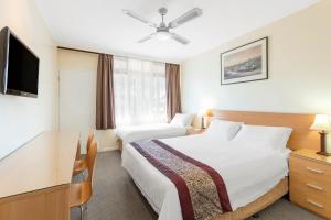 Habitación de hotel con cama grande y TV en Best Western Governor Gipps Motor Inn en Traralgon
