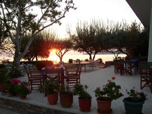 a patio with tables and chairs and flowers in pots at Hotel Votsala in Pyrgi Thermis +12 photos