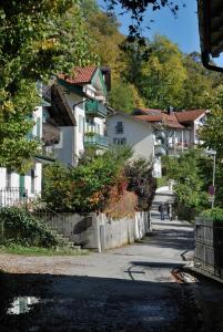 una calle con casas al lado de una colina en Malerhaus am Kolbergarten, en Bad Tölz