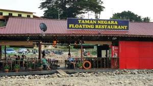 a restaurant with people sitting at tables in front of it at Taman Negara River View Lodge in Kuala Tahan +109 photos