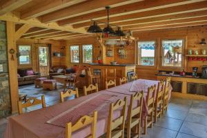 a dining room and kitchen with a long table and chairs at Bed and Breakfast Chalet Manava in Morzine
