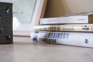 a stack of books sitting on a table at Murray Library Hostel in Anstruther