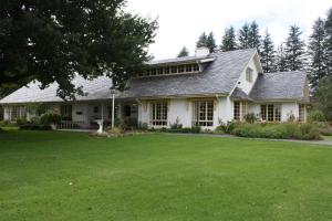 ein weißes Haus mit großem Rasen davor in der Unterkunft Cedar Garden in Underberg