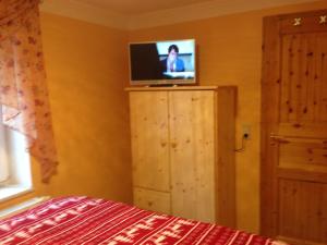 a bedroom with a television on top of a wooden cabinet at Ferienhaus 2 Am Eichenberg in Blankenburg