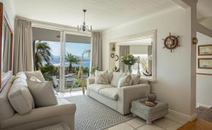 a living room with a couch and a large window at Ocean Watch Guest House in Plettenberg Bay
