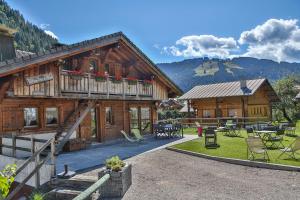 a large wooden house with a balcony and a patio at Bed and Breakfast Chalet Manava in Morzine