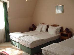 a hotel room with two beds and a window at Korona Panzió in Debrecen