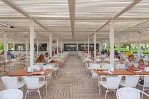 een restaurant met tafels en stoelen en mensen die er zitten bij Royal Alhambra Palace in Side