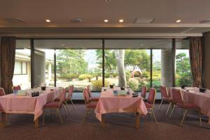 uma sala de conferências com mesas e cadeiras e uma grande janela em KKR Numazu Hamayu em Numazu