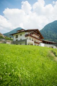 un edificio in cima a una collina erbosa di Residence Mairhof a San Leonardo in Passiria